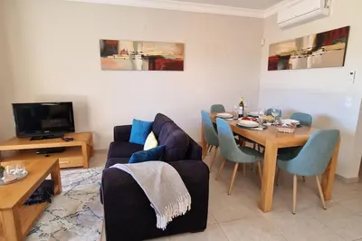 a living room with a table and a dining room at Deluxe 3 bedroom townhouse - Quinta da Atalaia in Lagos