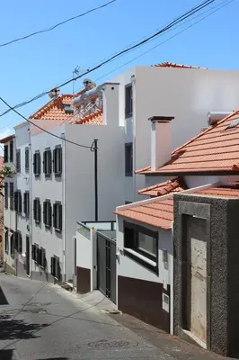 an alley between two white buildings with red roofs at Apartments Madeira Old Town in Funchal