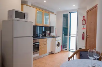 a kitchen with a refrigerator and a sink and a table at Apartments Madeira Old Town in Funchal