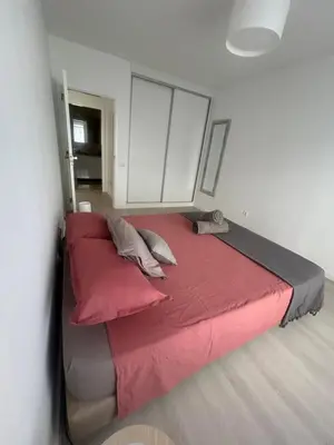 a bed with red sheets and pillows in a room at Lido Branca by Olá Madeira in Funchal