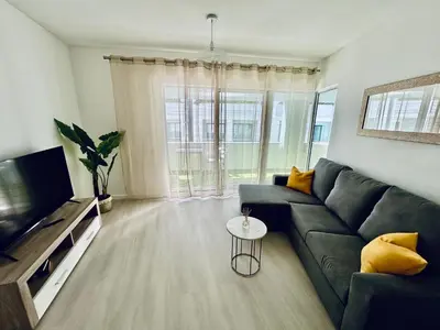 a living room with a couch and a television at Lido Branca by Olá Madeira in Funchal