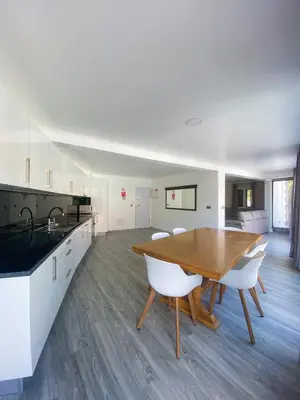 a kitchen and dining room with a wooden table and chairs at Village Square Coastal Apartment 2F in Machico