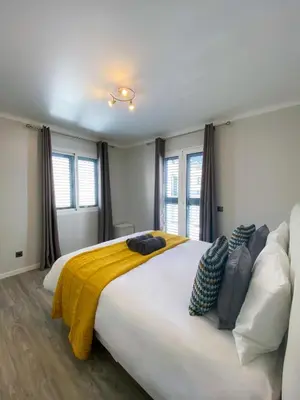a large white bed in a room with windows at Village Square Coastal Apartment 2F in Machico