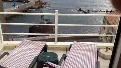 a balcony with two chairs and a view of the water at Harbour House in Paul do Mar