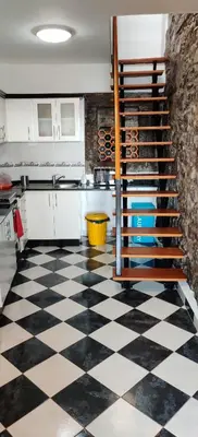 a kitchen with a black and white checkered floor at Harbour House in Paul do Mar