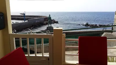a room with a view of the ocean and a statue at Harbour House in Paul do Mar