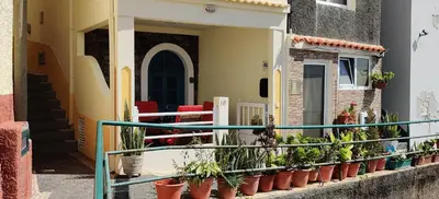 a balcony with potted plants on the side of a building at Harbour House in Paul do Mar