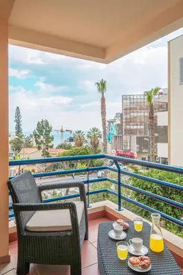 a living room with a couch and a flat screen tv at Lido Costa do Sol in Funchal