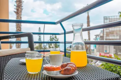 a living room with a dining table and a kitchen at Lido Costa do Sol in Funchal