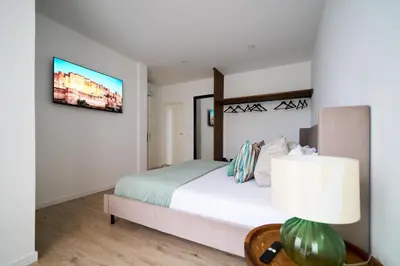 a bedroom with a large bed with green pillows at A Casa Da Mãe in São Vicente