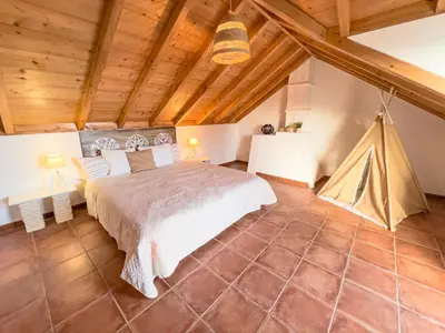a bedroom with a large bed and a wooden ceiling at Calheta Bay View House - Family and Group Residence in Arco da Calheta
