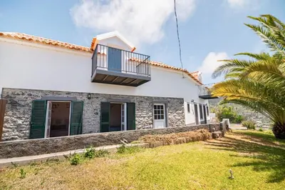 a house with a balcony and a yard at Calheta Bay View House - Family and Group Residence in Arco da Calheta