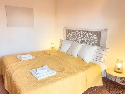 a bedroom with a bed with two towels on it at Calheta Bay View House - Family and Group Residence in Arco da Calheta