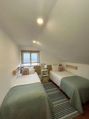 two beds in a small room with a window at Refúgio do Seixal in Seixal