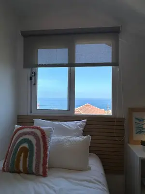 a bedroom with a window with a view of the ocean at Refúgio do Seixal in Seixal