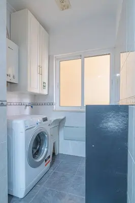 a kitchen with white cabinets and a stove top oven at Ocean View Apartment in Caniço de Baixo in Funchal