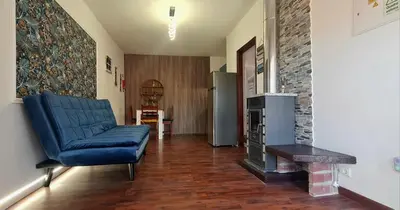 a living room with a blue couch and a fireplace at Casa Monte de Paz in Calheta