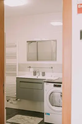 a kitchen with a washing machine and a sink at Casa Analino in Feiteiras