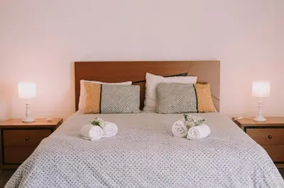 a bed with three rolled towels on it at Casa Analino in Feiteiras