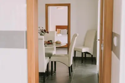 a dining room with a table and chairs and a mirror at Casa Analino in Feiteiras