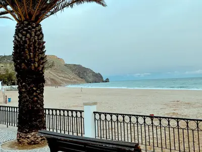 a group of people walking on a pier near the water at Beautiful sea view in Luz