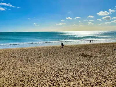 a person walking on a beach near the ocean at Beautiful sea view in Luz