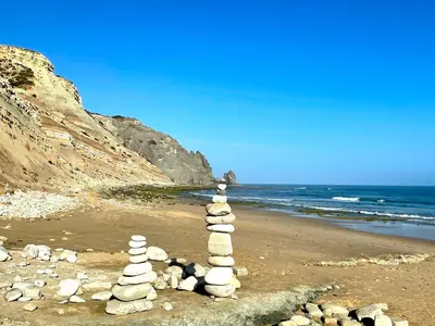 a stack of rocks on a beach near the ocean at Beautiful sea view in Luz