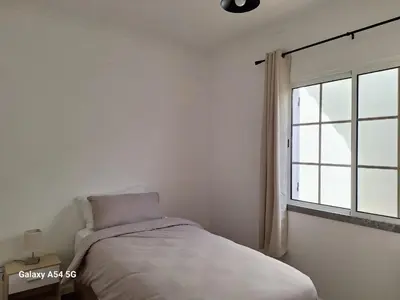 a white bedroom with a bed and a window at Figueira's House By the Atlantic in Ponta do Sol