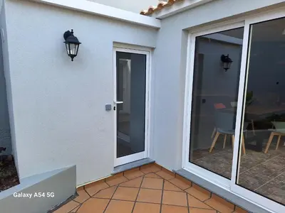 a sliding glass door on a house with a patio at Figueira's House By the Atlantic in Ponta do Sol