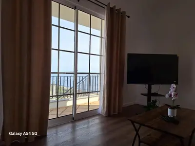 a living room with a large sliding glass door with a balcony at Figueira's House By the Atlantic in Ponta do Sol