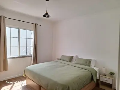 a white bedroom with a bed and a window at Figueira's House By the Atlantic in Ponta do Sol