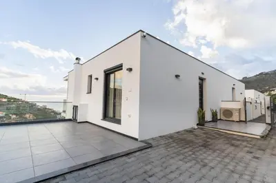 a white house with a view of the ocean at Villa Fénix in Câmara de Lobos