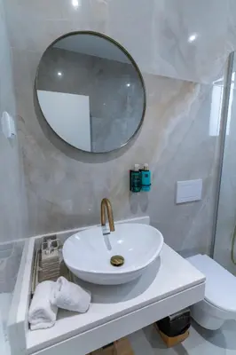 a bathroom with a sink and a mirror and a toilet at Villa Fénix in Câmara de Lobos