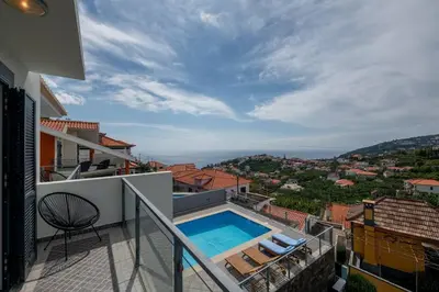 a balcony with a swimming pool on top of a building at Luxury Haven: Heated Pool, AC & Sun in Ponta do Sol