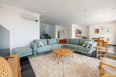 a living room with a blue couch and a table at Luxury Haven: Heated Pool, AC & Sun in Ponta do Sol