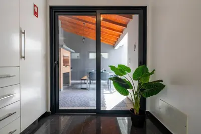 a kitchen with a sliding glass door with a plant at Luxury Haven: Heated Pool, AC & Sun in Ponta do Sol