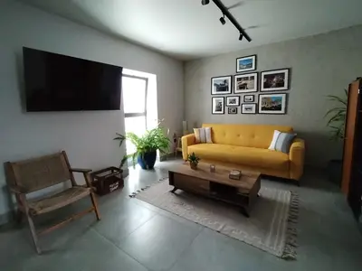 a living room with a yellow couch and a tv at Casa do Favinha in Machico