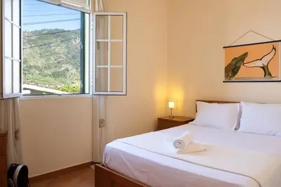 a bedroom with a large white bed with a window at Hikers Haven in Faial