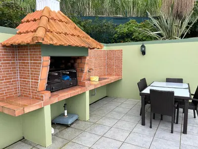 a patio with a brick oven with a table and chairs at Hikers Haven in Faial