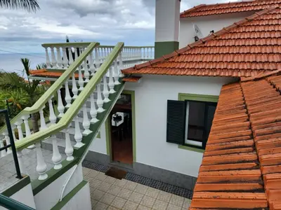 a house with a staircase leading to a door at Hikers Haven in Faial