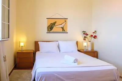 a bedroom with a large white bed with two lamps at Hikers Haven in Faial
