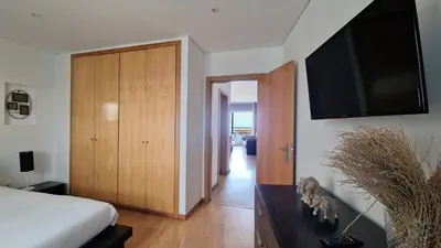 a bedroom with a bed and a flat screen tv at Azenha Apartment by LovelyStay in Caniço