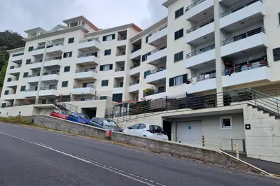 a large white building with cars parked in front of it at Azenha Apartment by LovelyStay in Caniço
