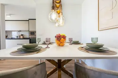 a dining room table with a bowl of fruit and wine glasses at SeaLaVie Apartment in Funchal