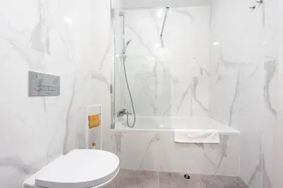 a white bathroom with a shower and a toilet at SeaLaVie Apartment in Funchal