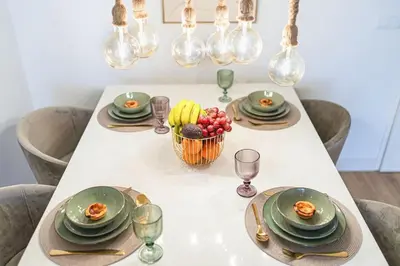 a white table with plates and a bowl of fruit at SeaLaVie Apartment in Funchal