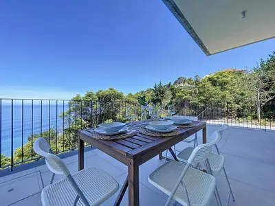 a wooden table and chairs on a balcony at Mar Yam Garden by Atlantic Holiday in Arco de São Jorge