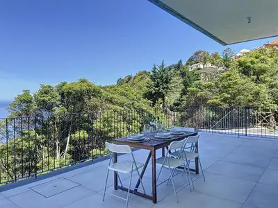 a table with chairs and plates on a balcony at Mar Yam Garden by Atlantic Holiday in Arco de São Jorge