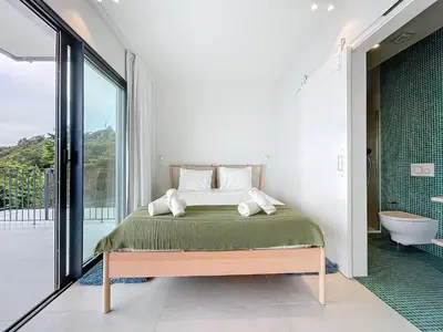 a bedroom with a bed and a bathroom with a tub at Mar Yam Garden by Atlantic Holiday in Arco de São Jorge