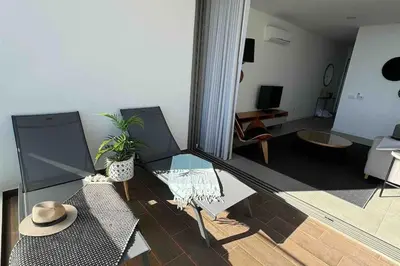 a living room with a glass table and a hat at Gaivota Ocean view & 5min walk beach in Luz